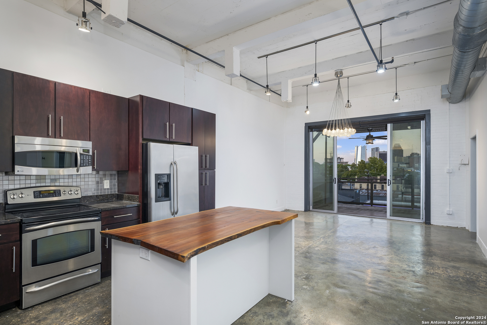 a kitchen with kitchen island a counter top space stainless steel appliances and cabinets