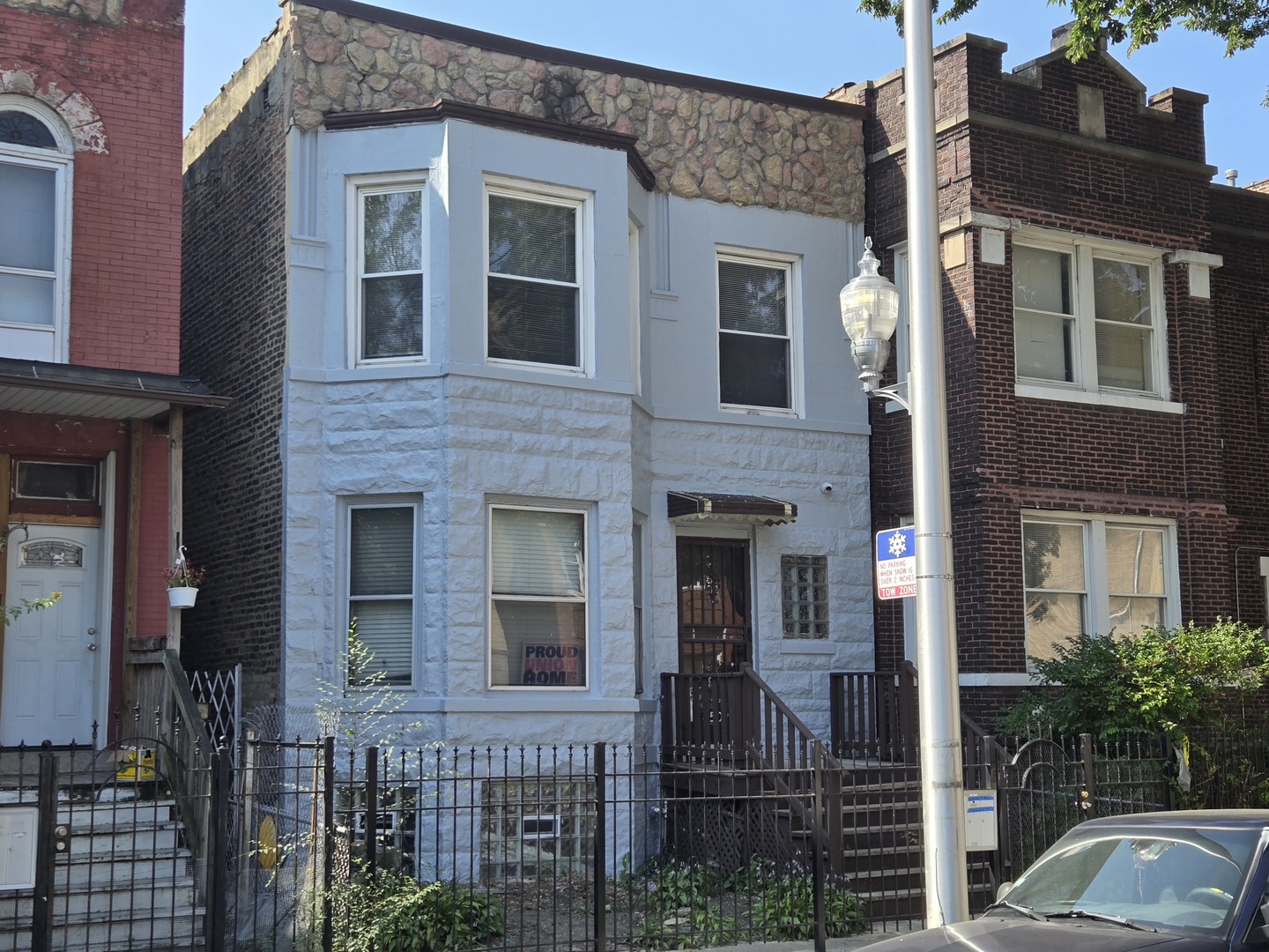 a view of a brick house with large windows and a flower plants