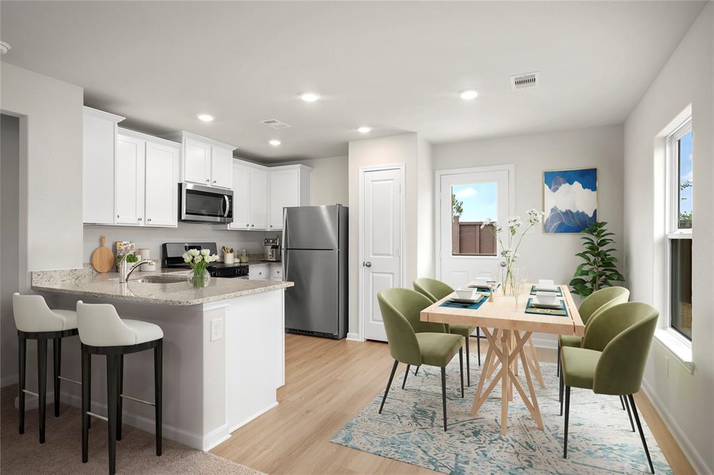 a kitchen with refrigerator a kitchen island and chairs in it