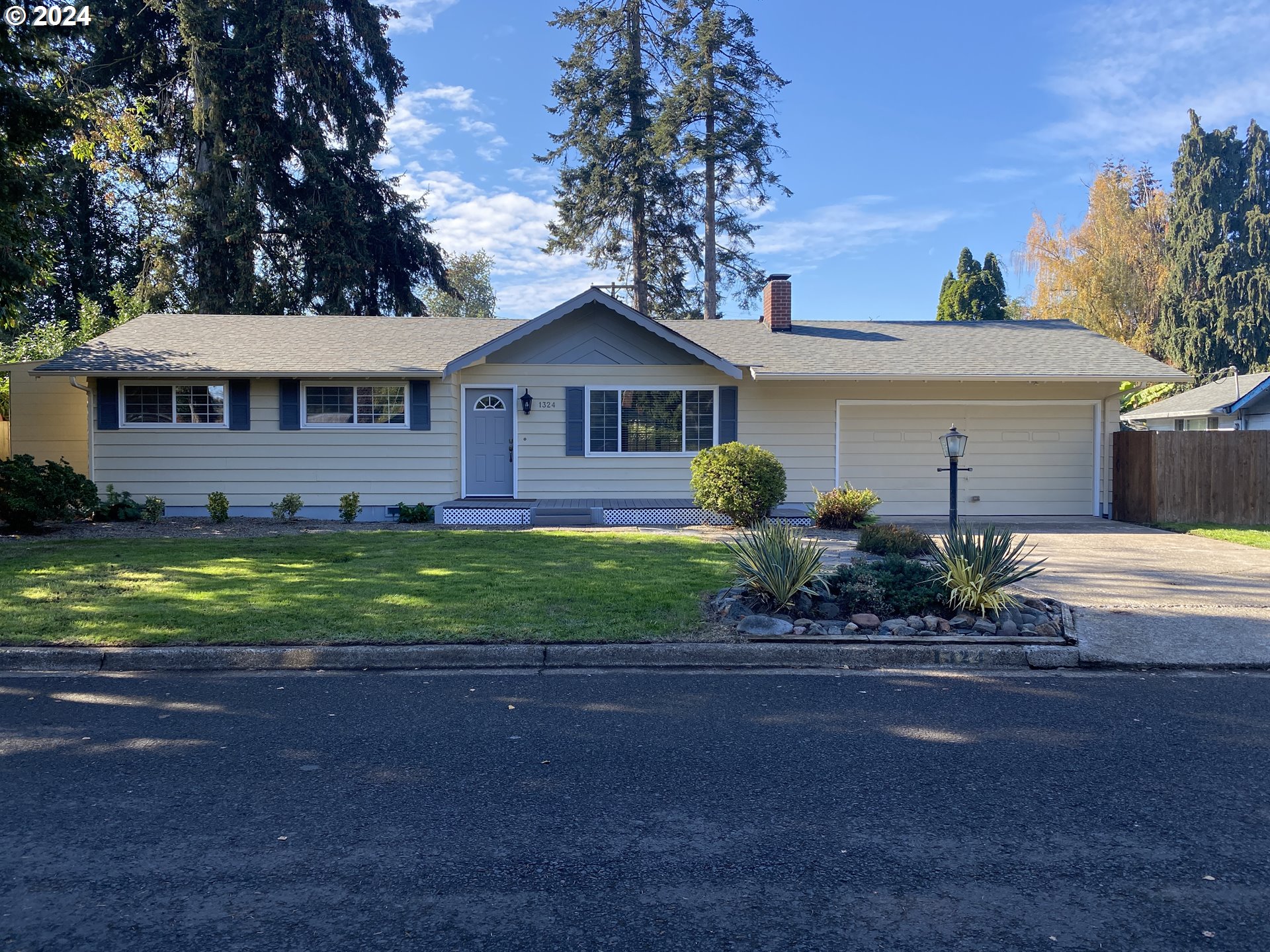 a front view of a house with a garden and yard