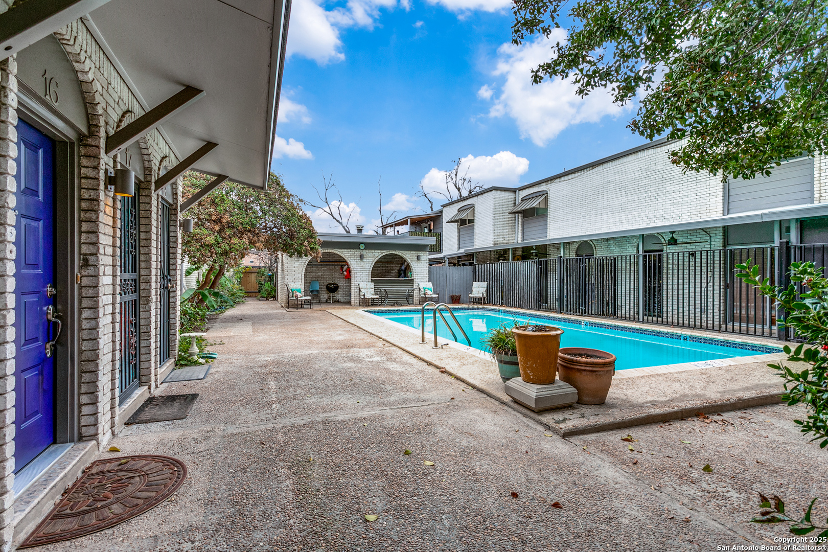 a view of a patio with couches and table and chairs next to a yard