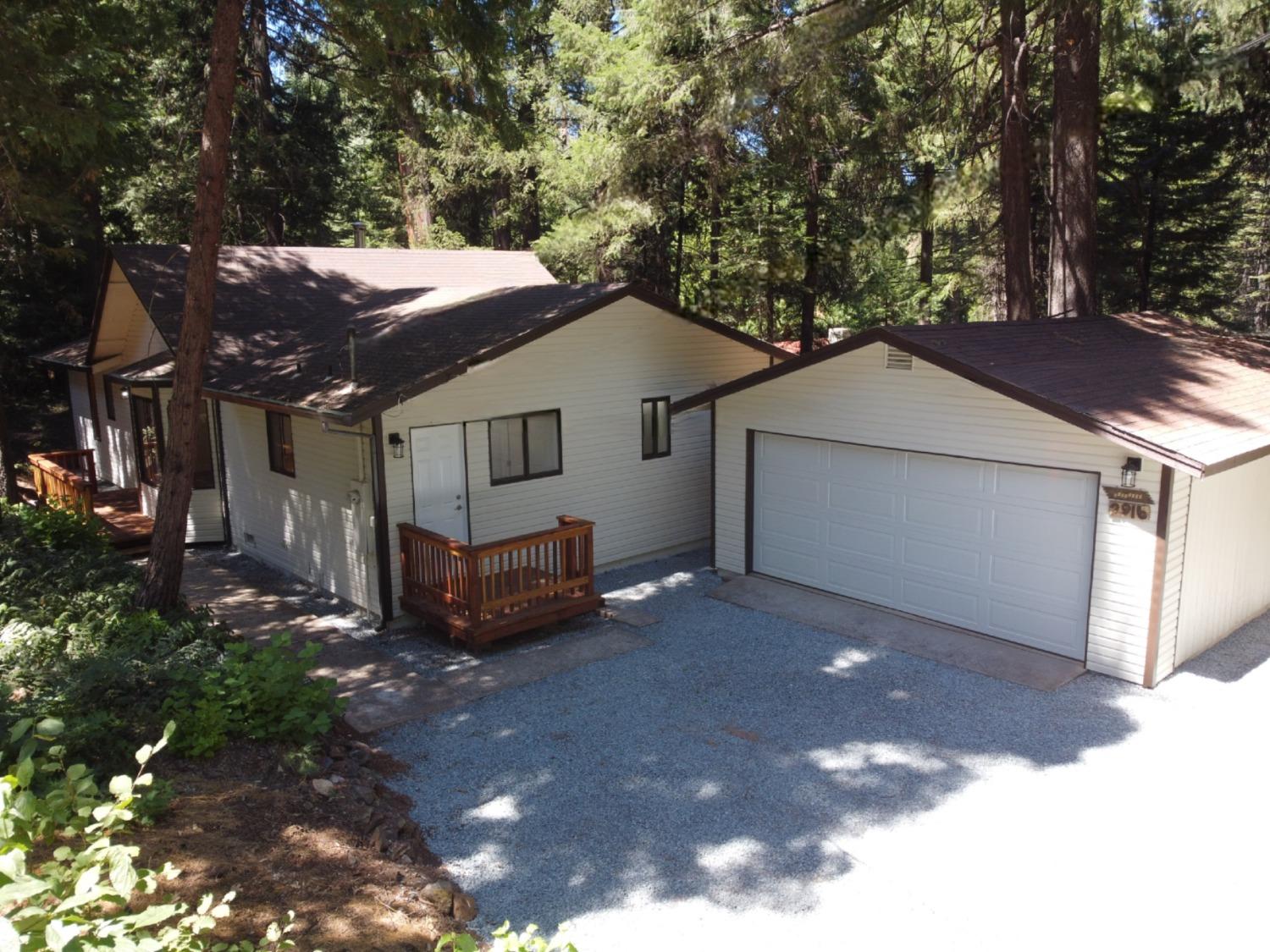 a view of a house with a yard and large tree