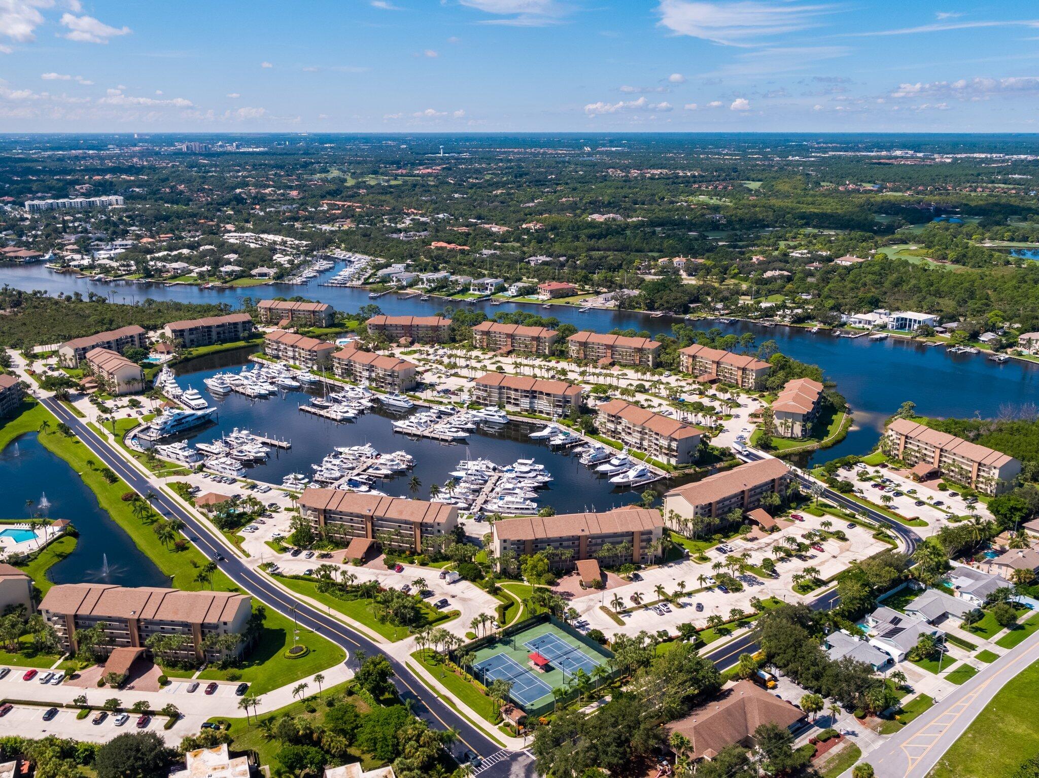 an aerial view of a city with lots of residential buildings and ocean view in back