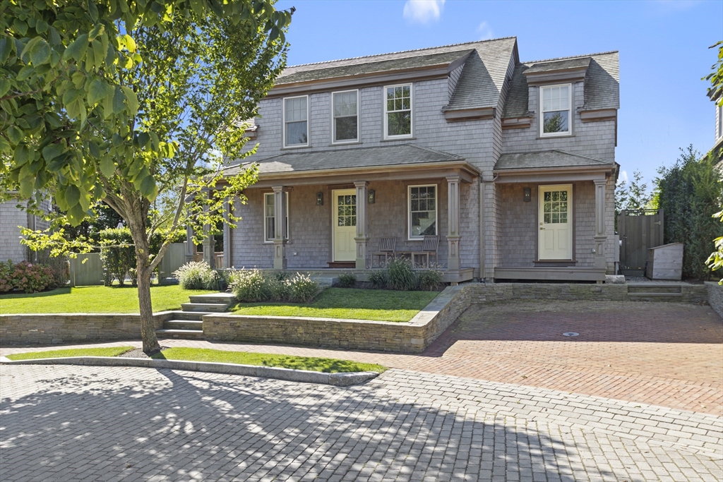 a view of a house with a yard and a large tree