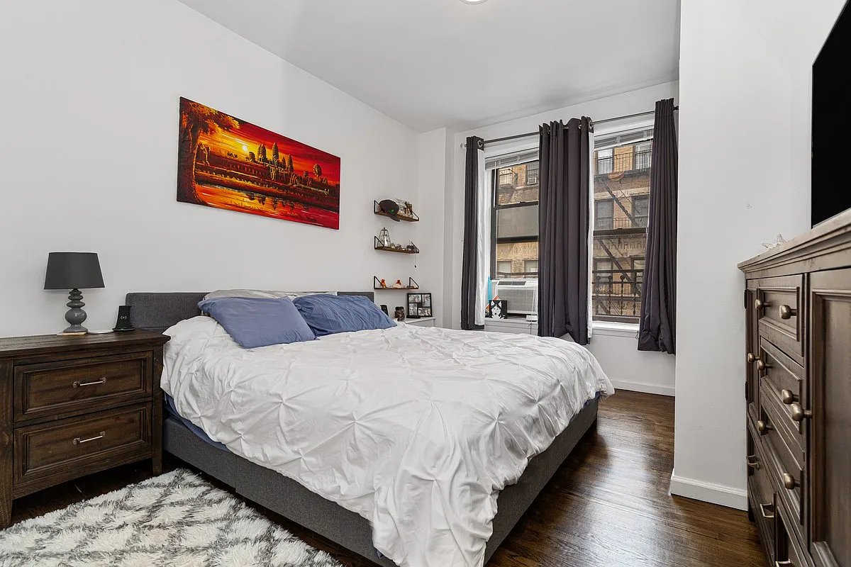 a large bed sitting in a bedroom next to a window