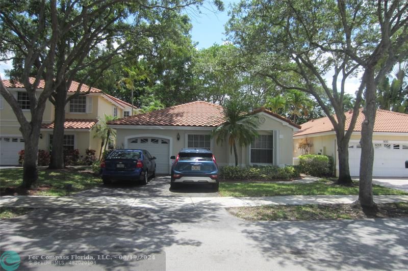 a front view of a house with a yard and trees