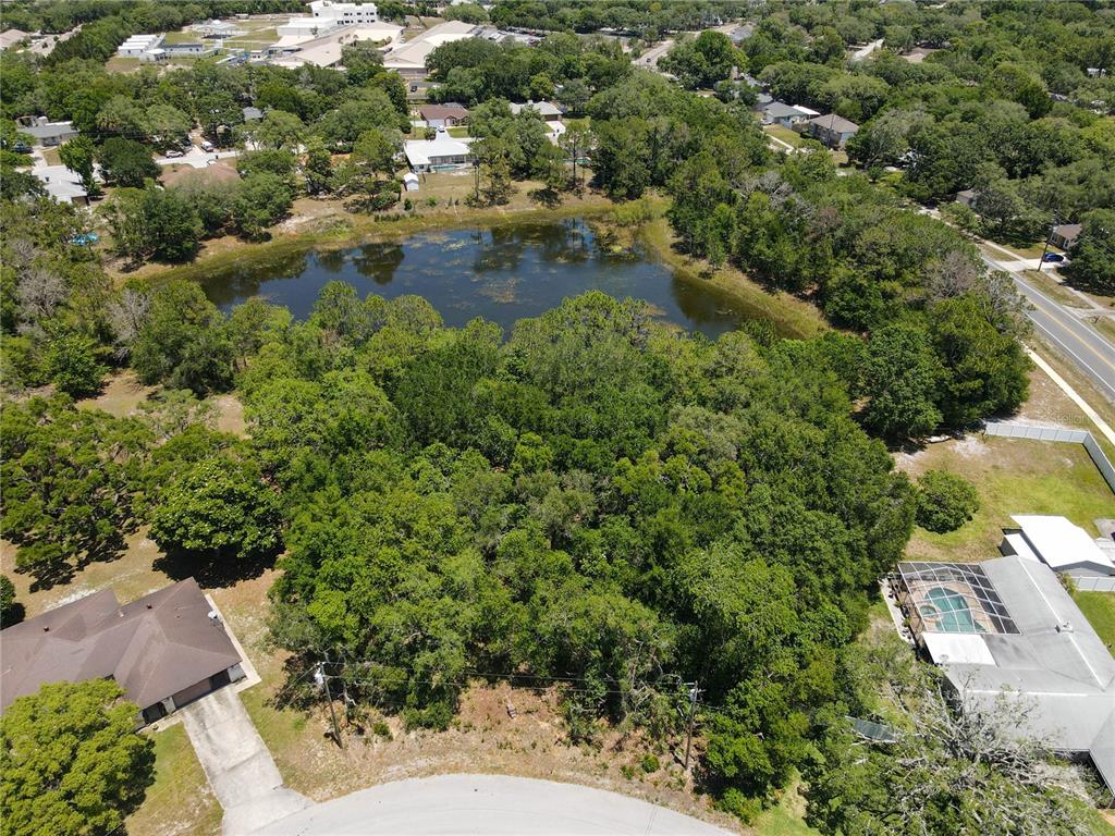 an aerial view of residential house with outdoor space and trees all around