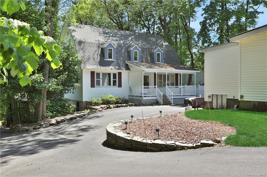 a front view of a house with a yard and trees