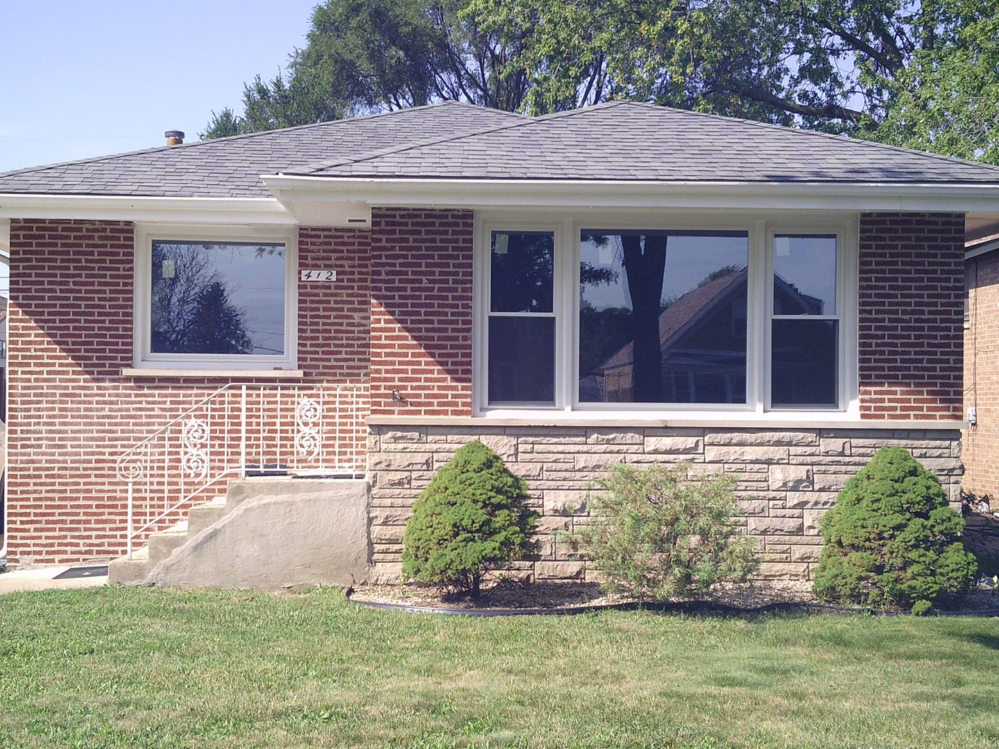 a front view of a house with a garden