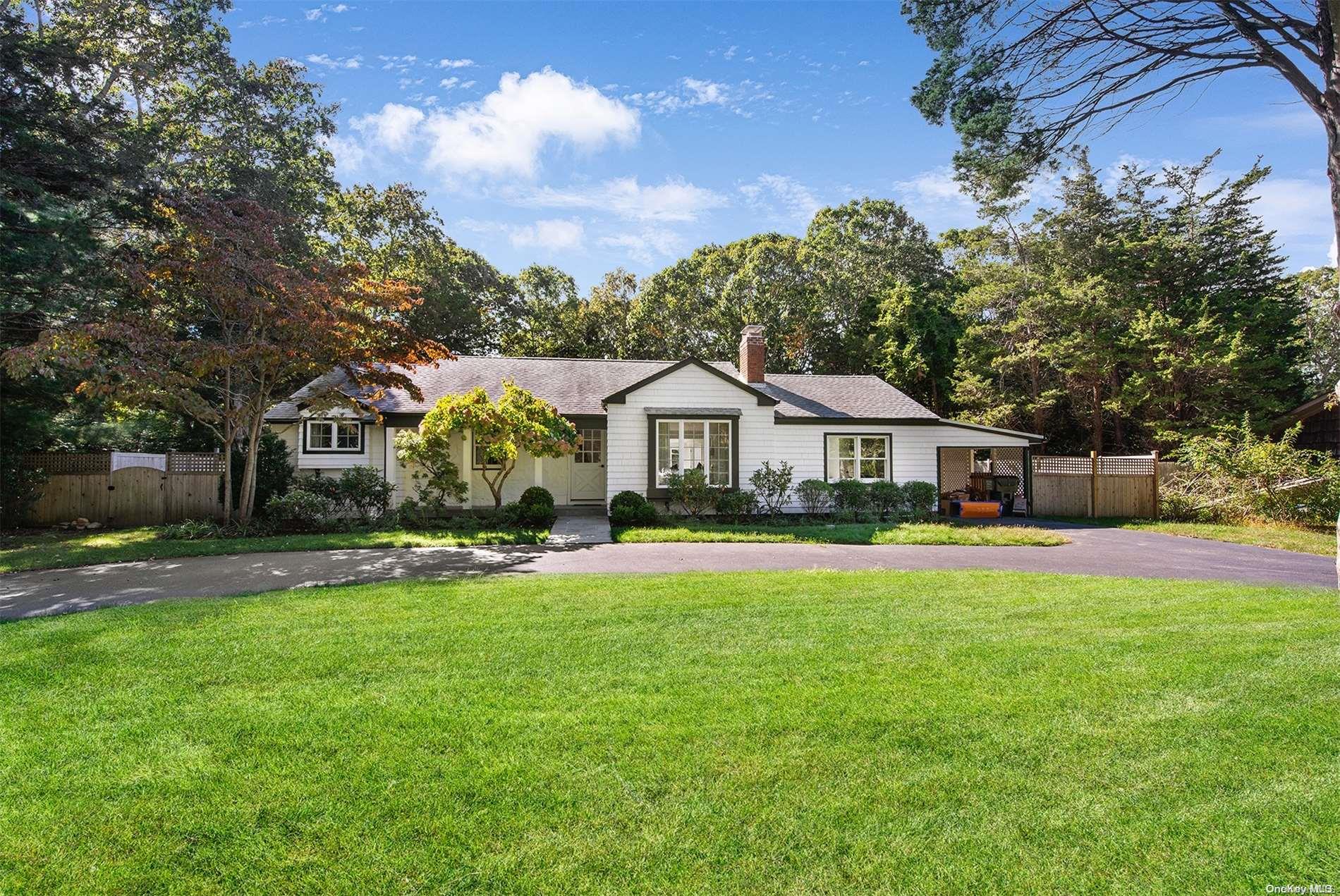 a front view of a house with yard and green space