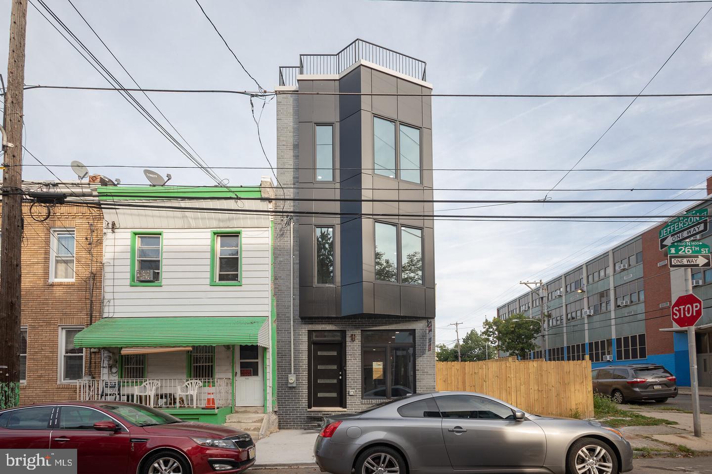 a front view of a building with cars parked