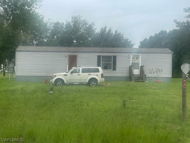 a front view of house with yard and trees in the background