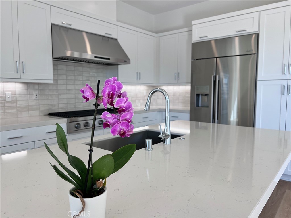 a kitchen with a refrigerator and a potted plant