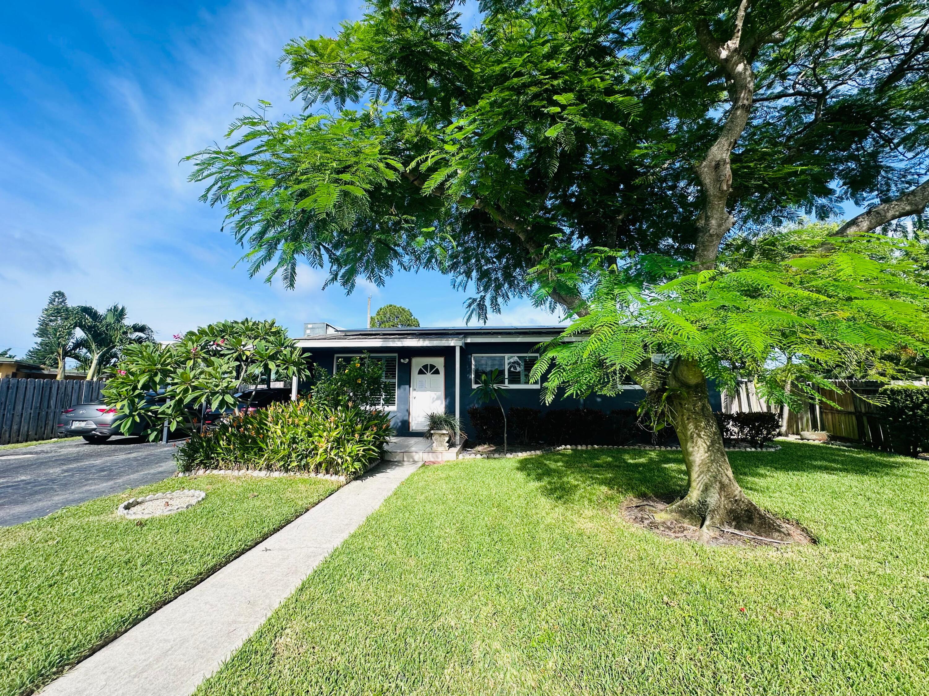 a view of a house with a yard and potted plants