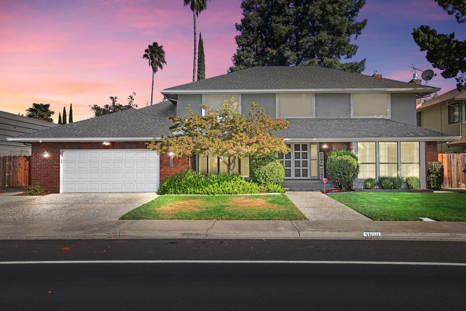 a front view of a house with a yard and potted plants