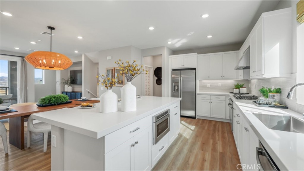 a kitchen with stainless steel appliances kitchen island granite countertop a sink a stove and a refrigerator