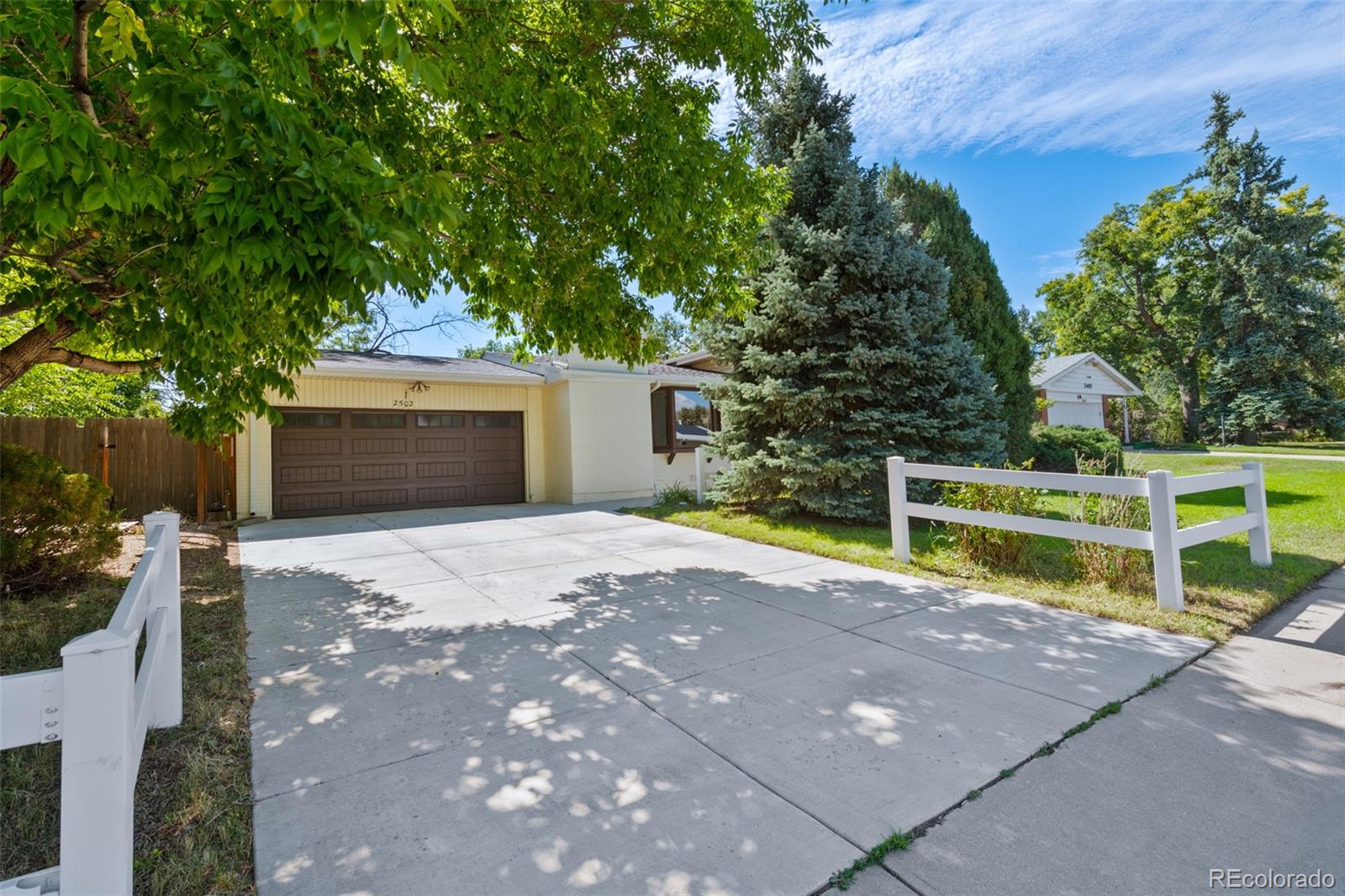 a view of a house with backyard and a tree