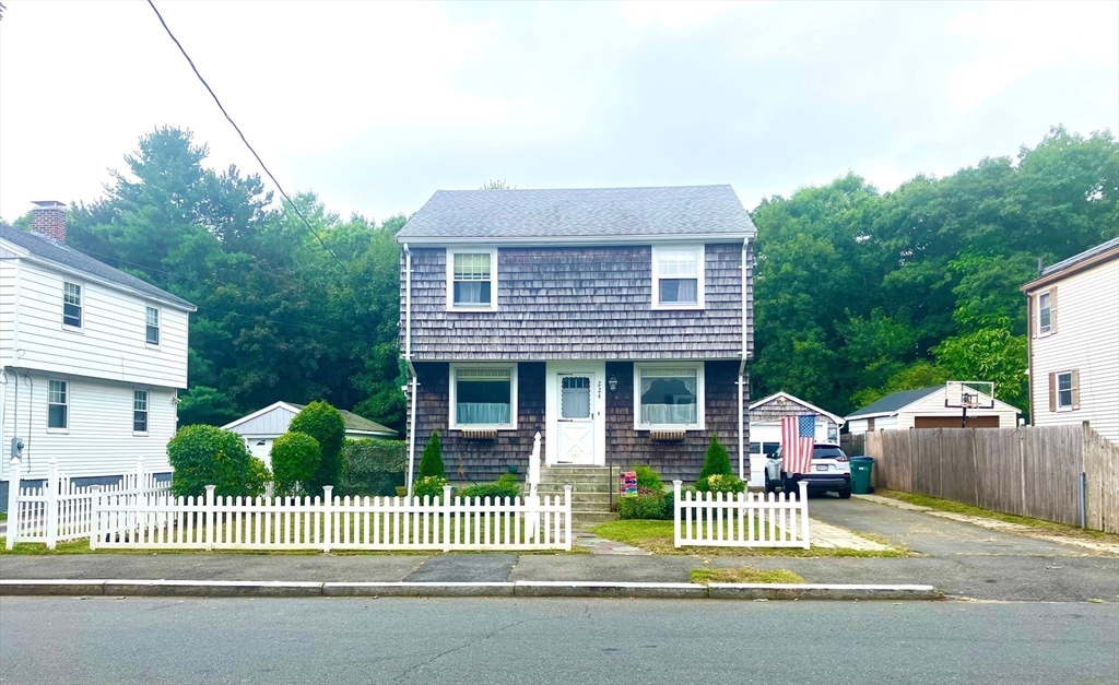 a front view of a house with a garden and plants