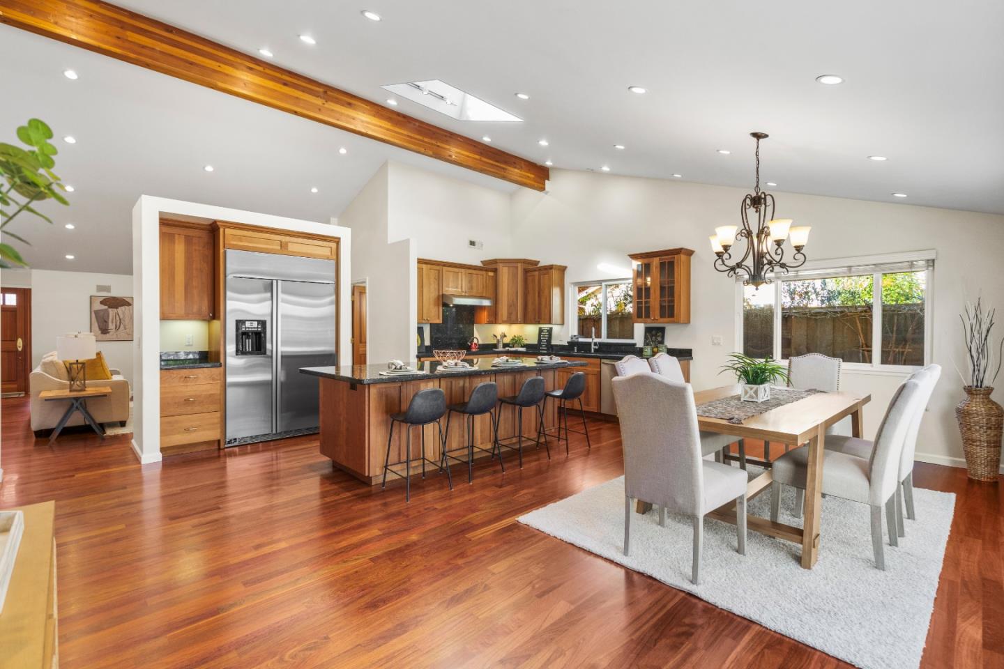 a dining room with furniture a kitchen and chandelier