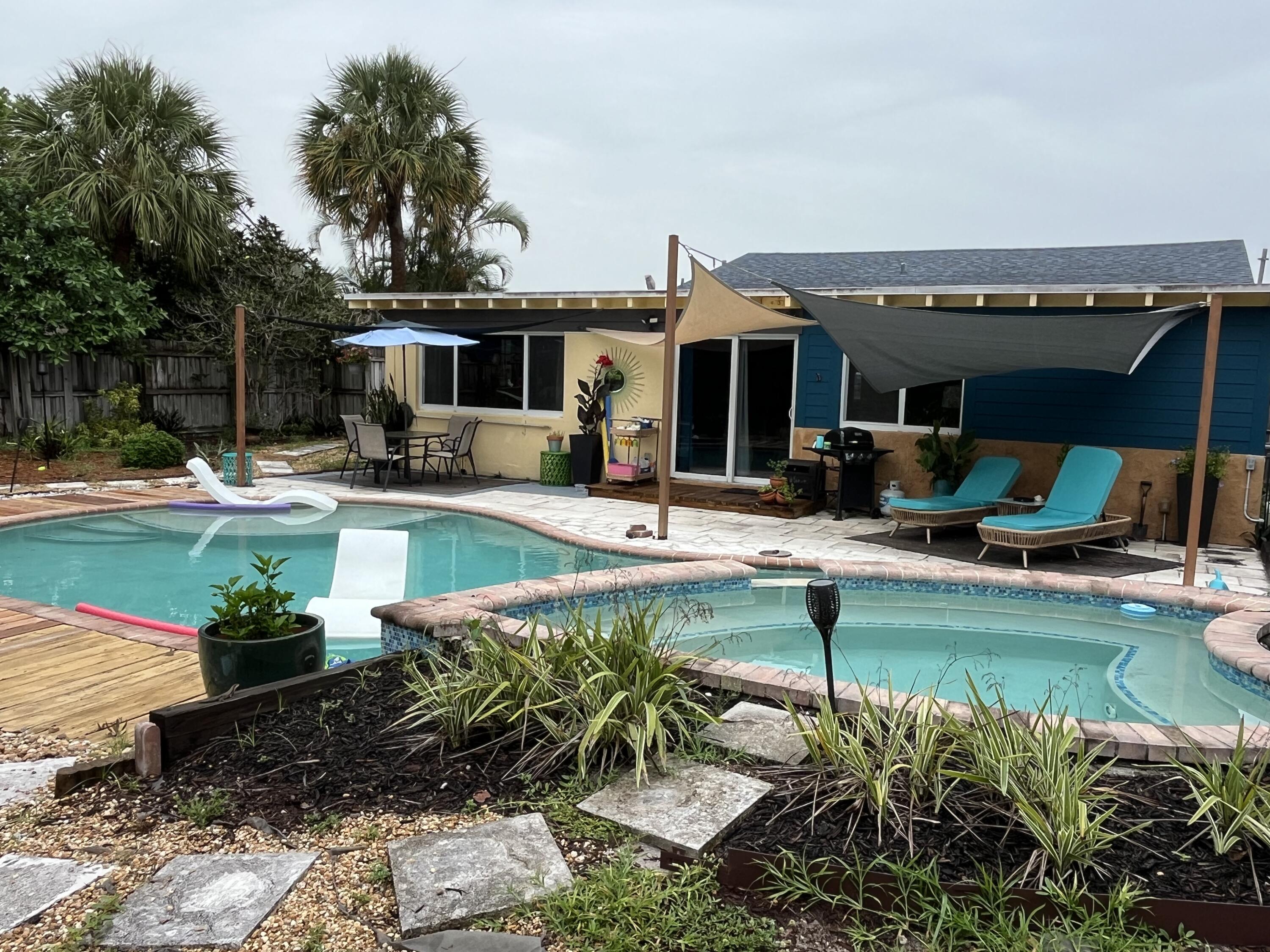 a view of a house with swimming pool and sitting area