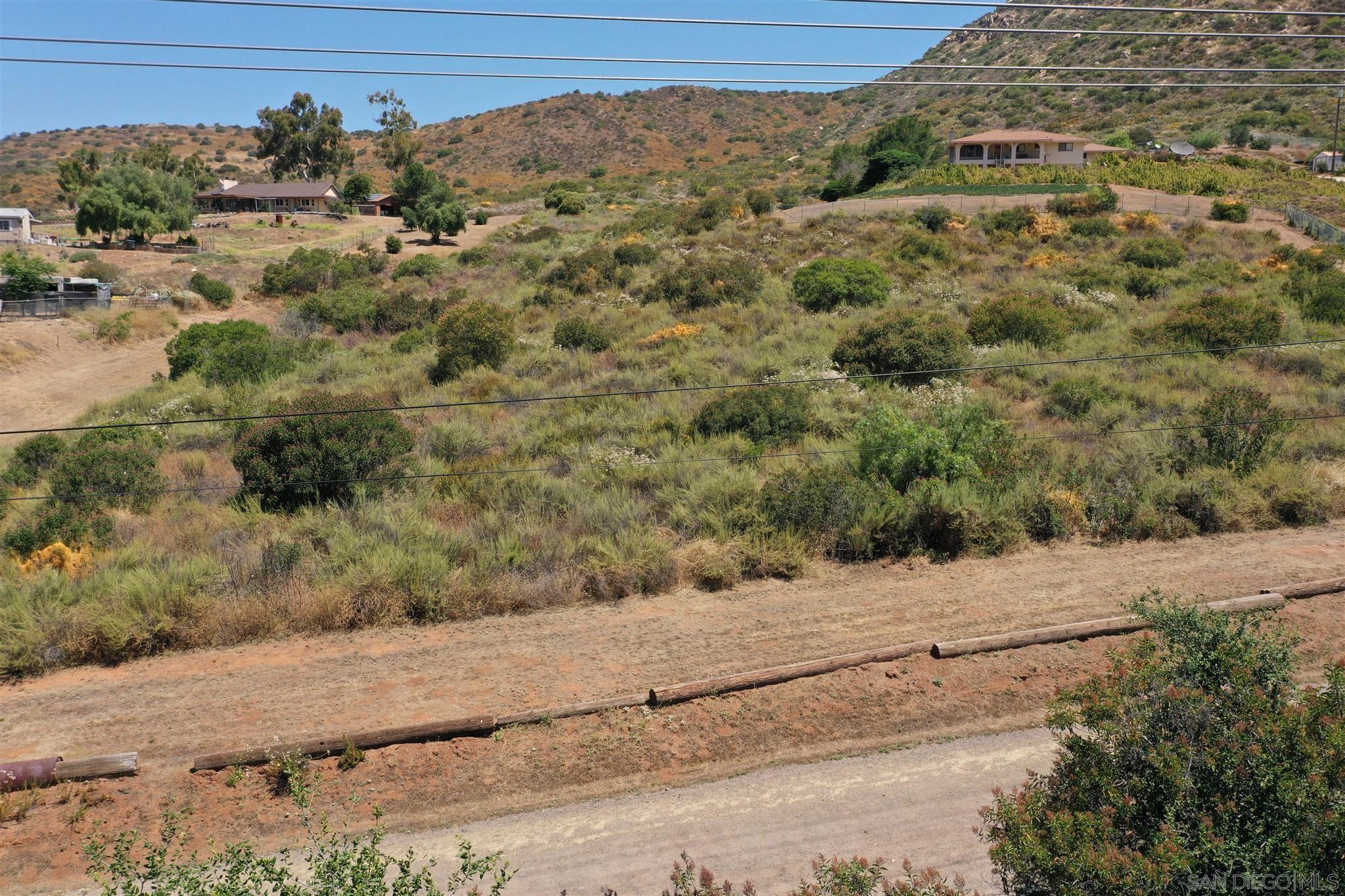 a view of a dry yard with wooden fence