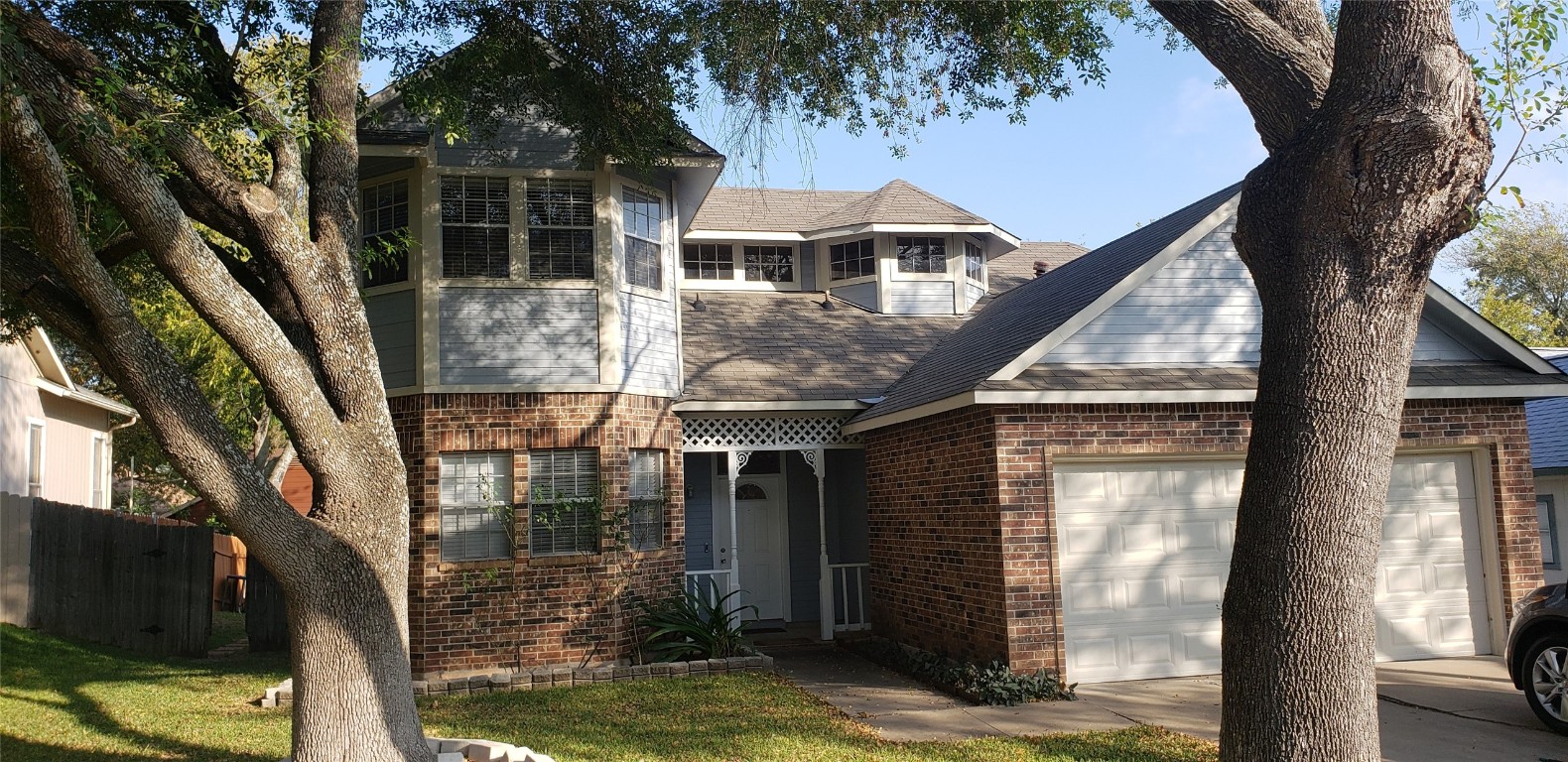 a view of a house with brick walls and a small yard