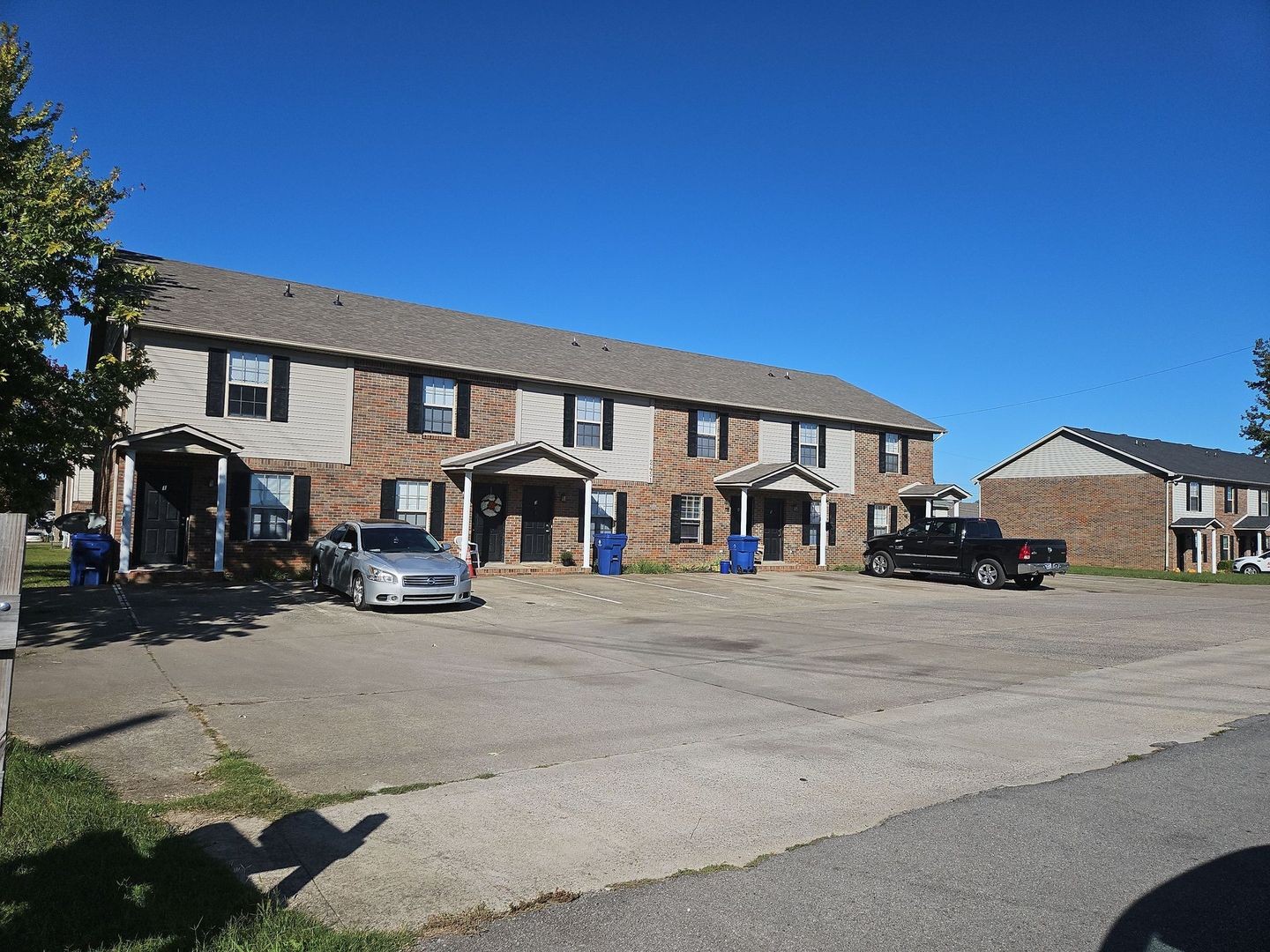 a front view of a house with cars parked in front of house