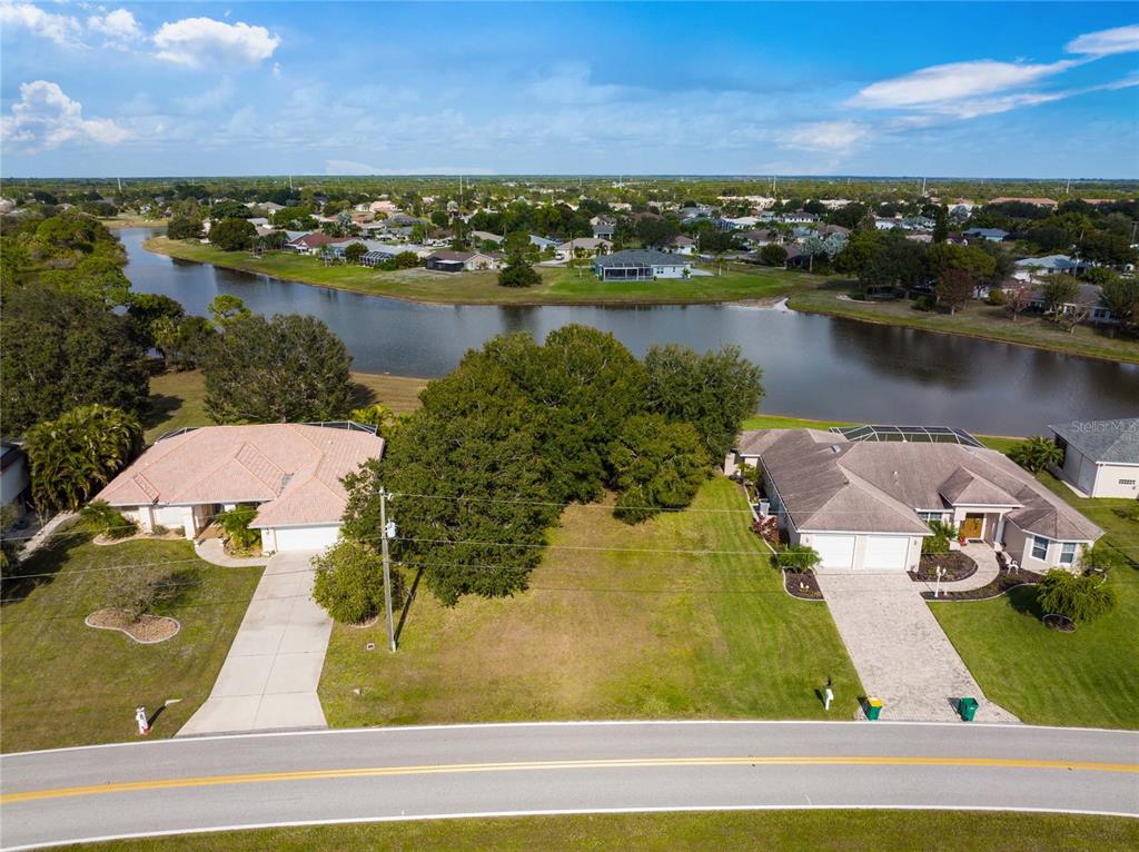 an aerial view of residential houses with outdoor space and ocean view