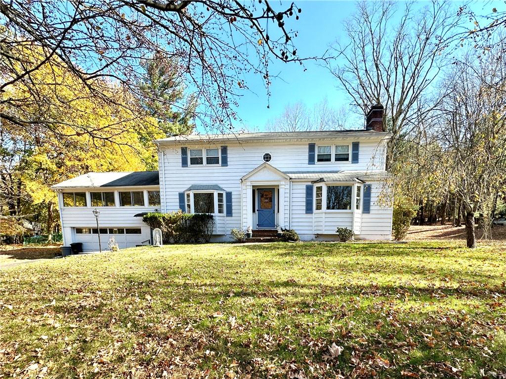 View of front of house featuring a front lawn and a garage