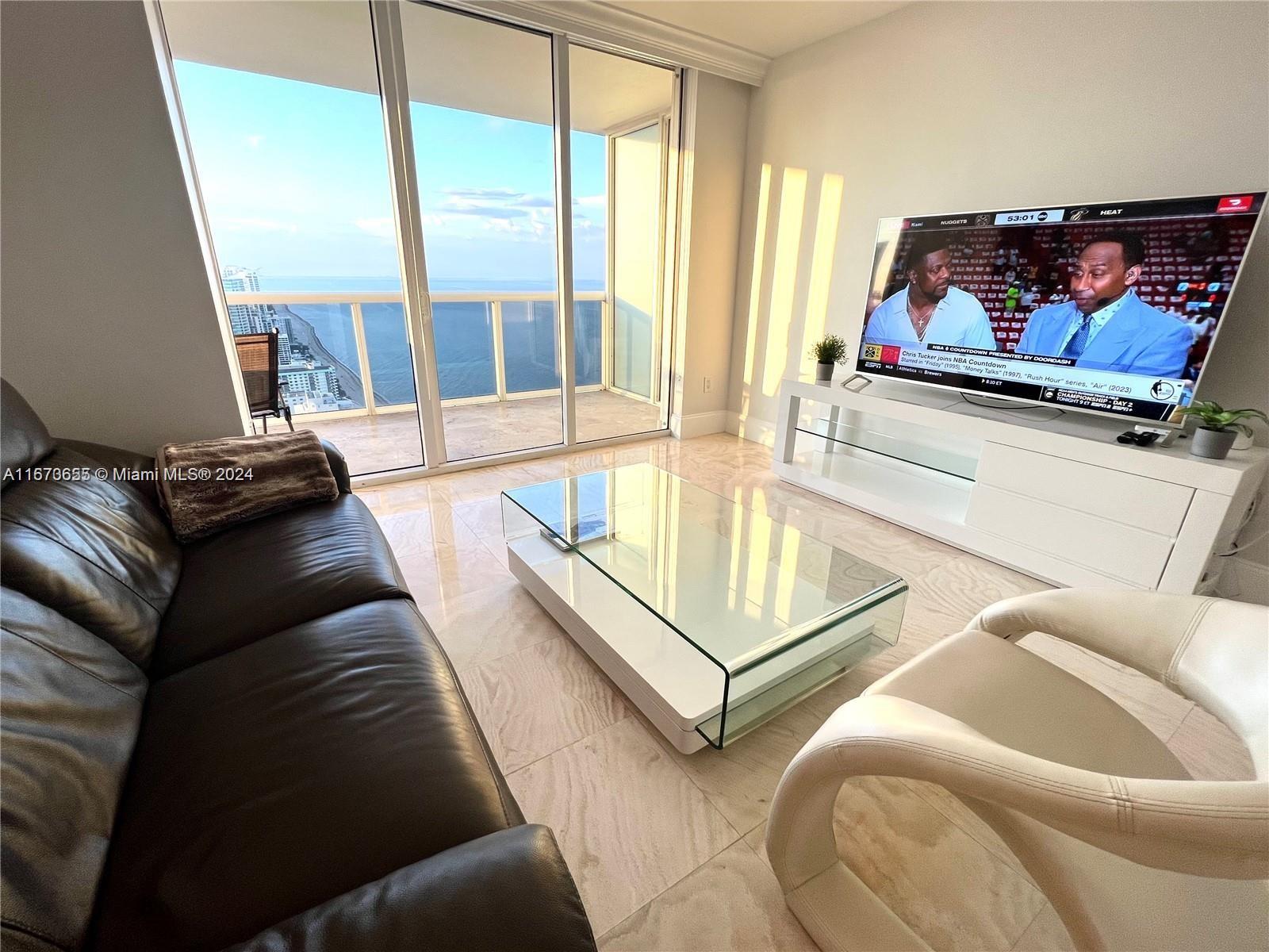 a living room with furniture and a floor to ceiling window