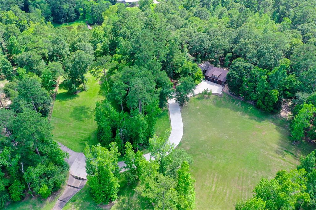 an aerial view of residential house with outdoor space and trees all around