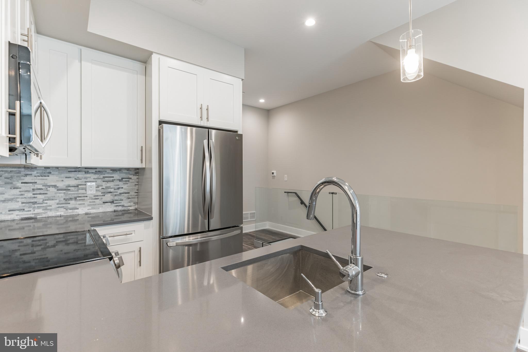 a view of a kitchen with a sink and a refrigerator