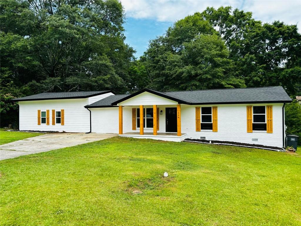 a front view of house with yard and trees in the background