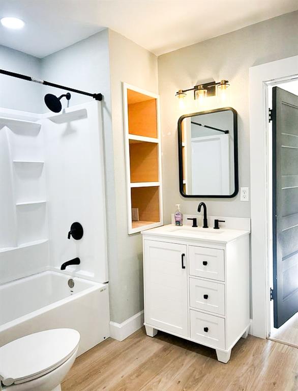 a bathroom with a bathtub sink mirror vanity and toilet