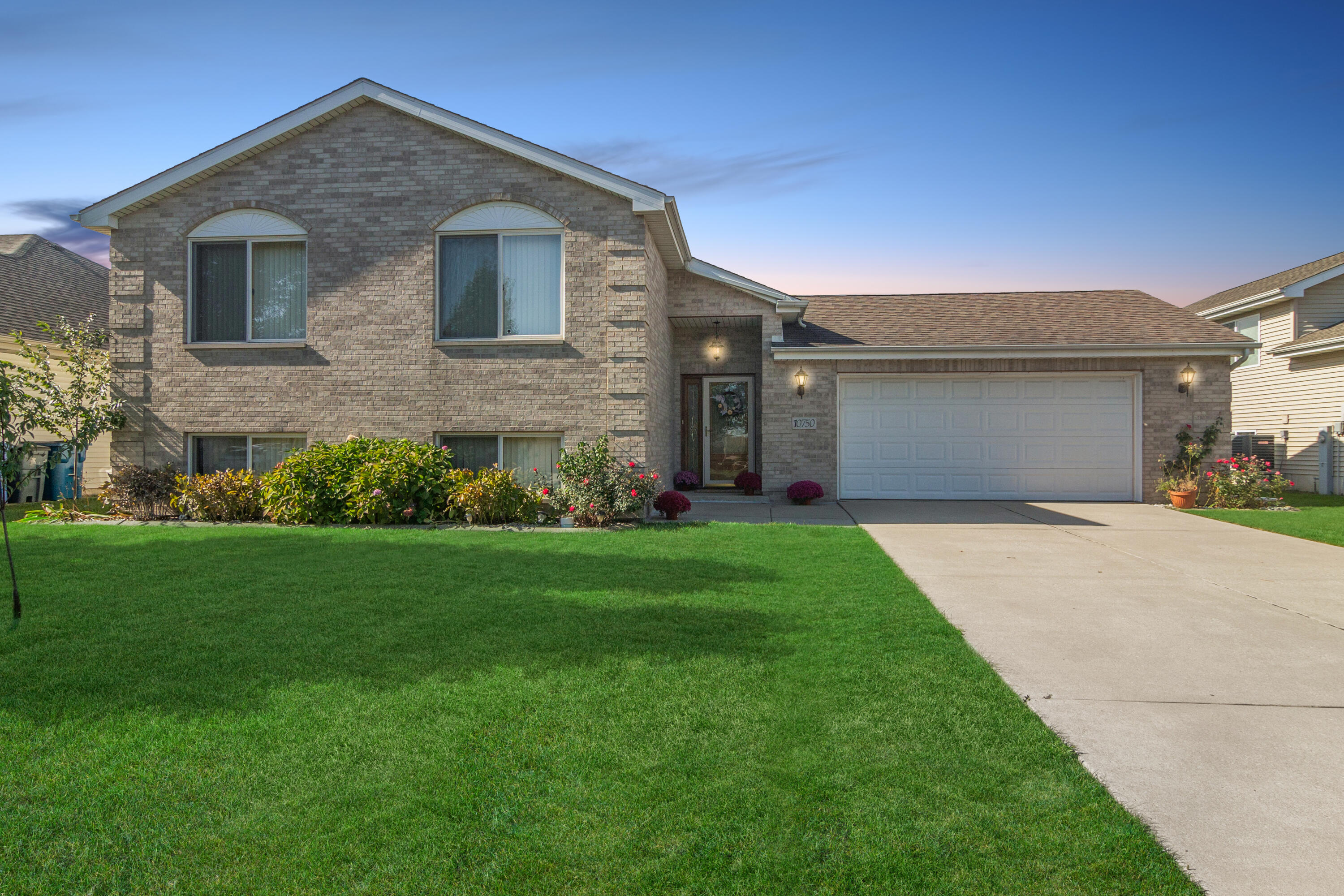 a front view of a house with a garden and yard