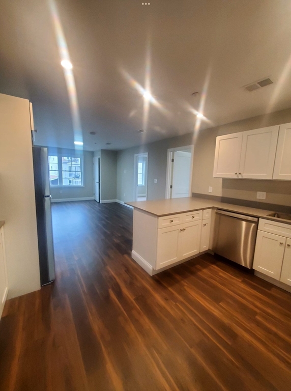 a large white kitchen with cabinets