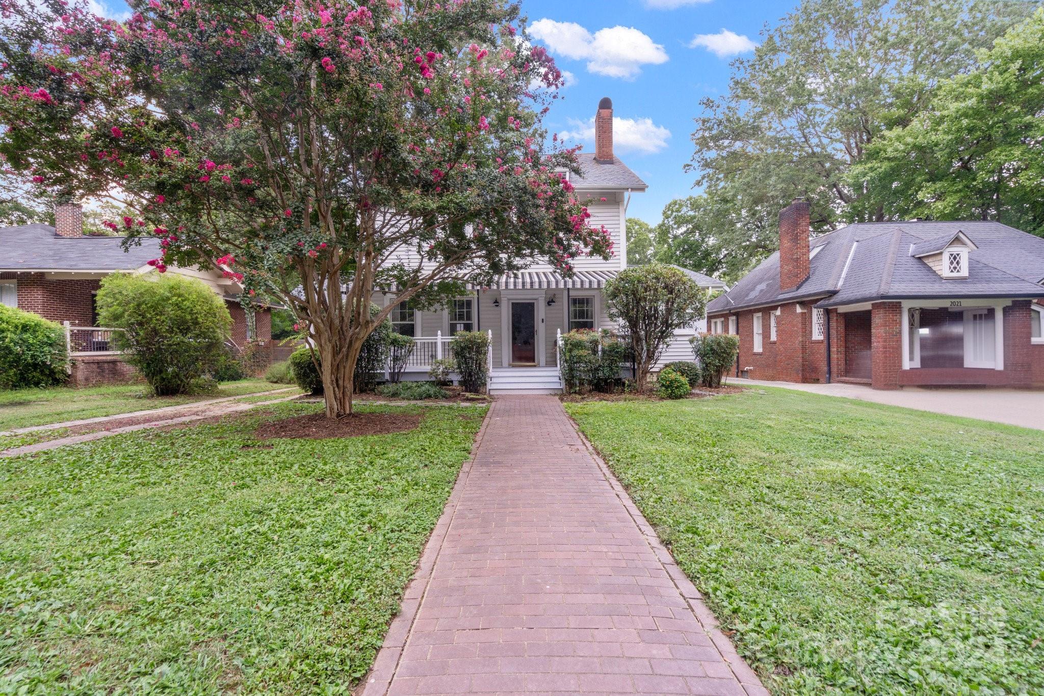 a front view of a house with yard and green space