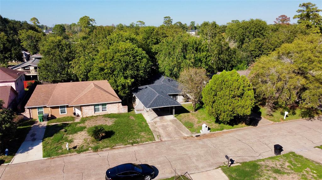 an aerial view of a house with yard and green space