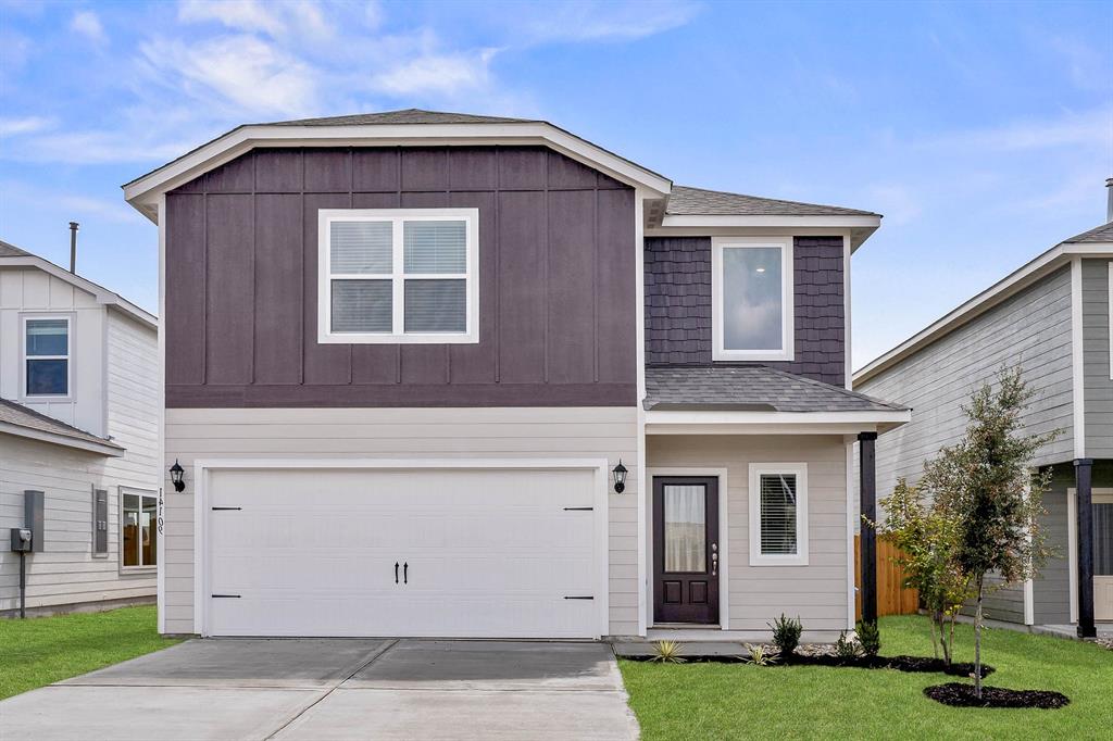 View of front property featuring a front yard and a garage