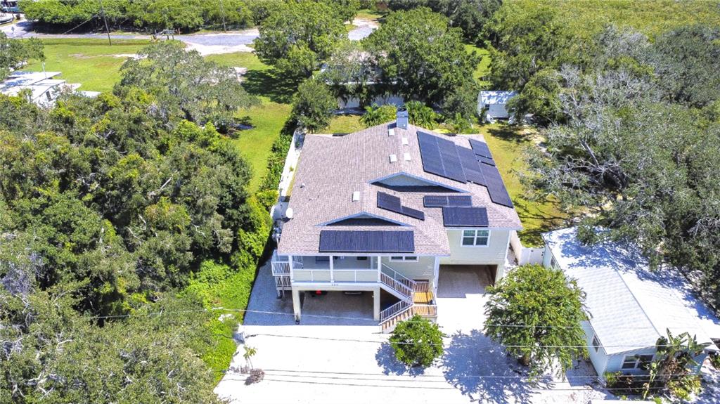 an aerial view of a house with a garden and lake view