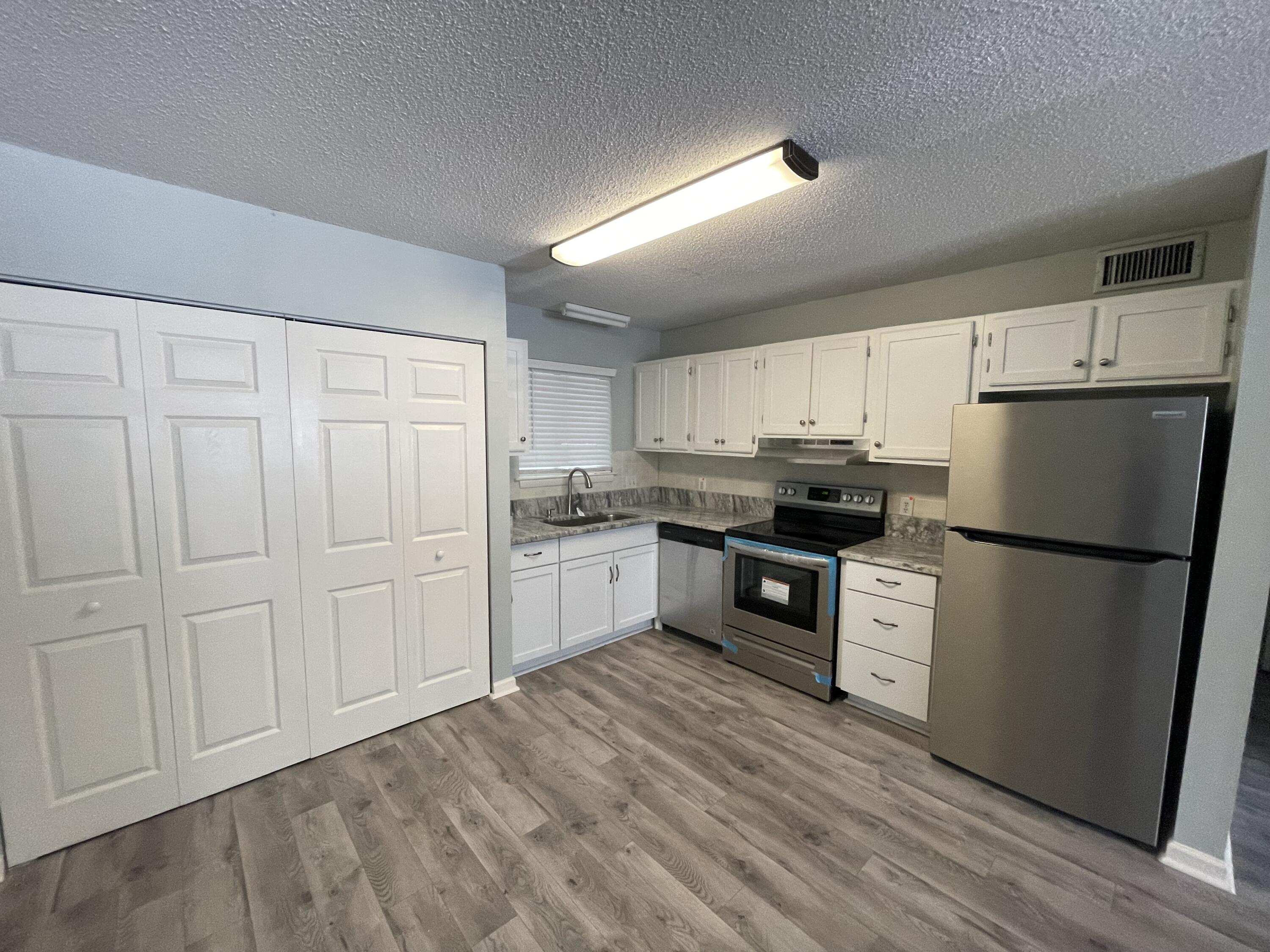 a kitchen with white cabinets and white appliances