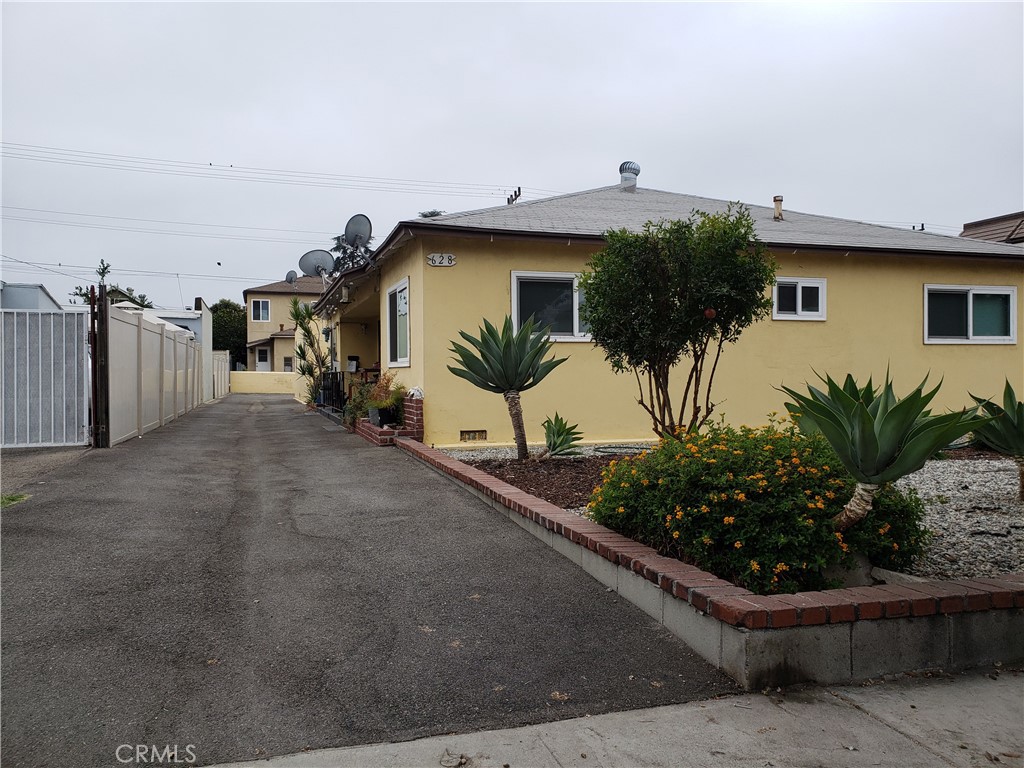 a view of a house with a small yard and potted plants