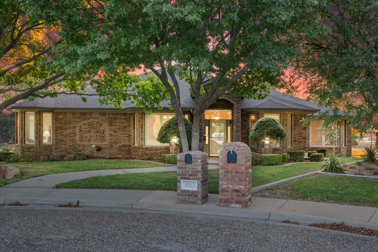 a front view of a house with a yard and trees