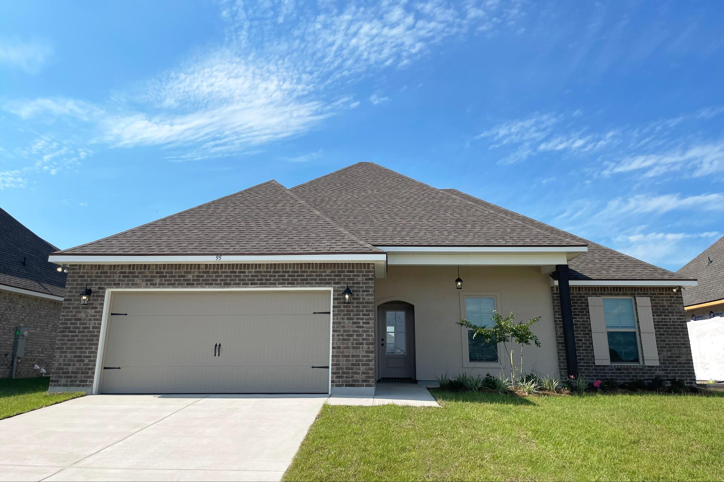 a front view of a house with a garden and yard