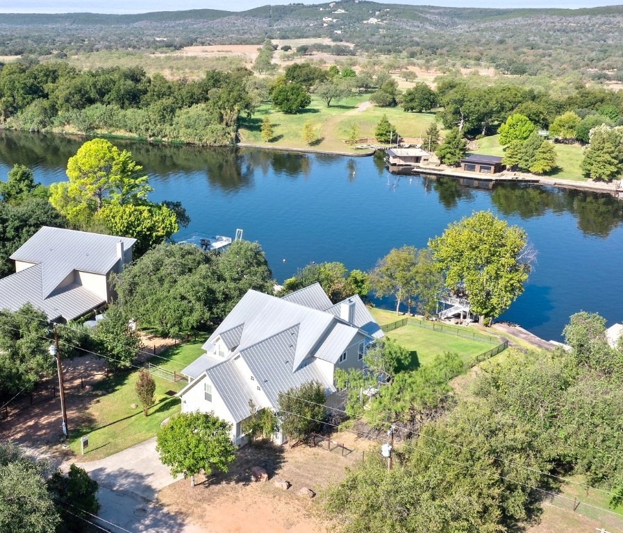 an aerial view of residential houses with outdoor space and lake view