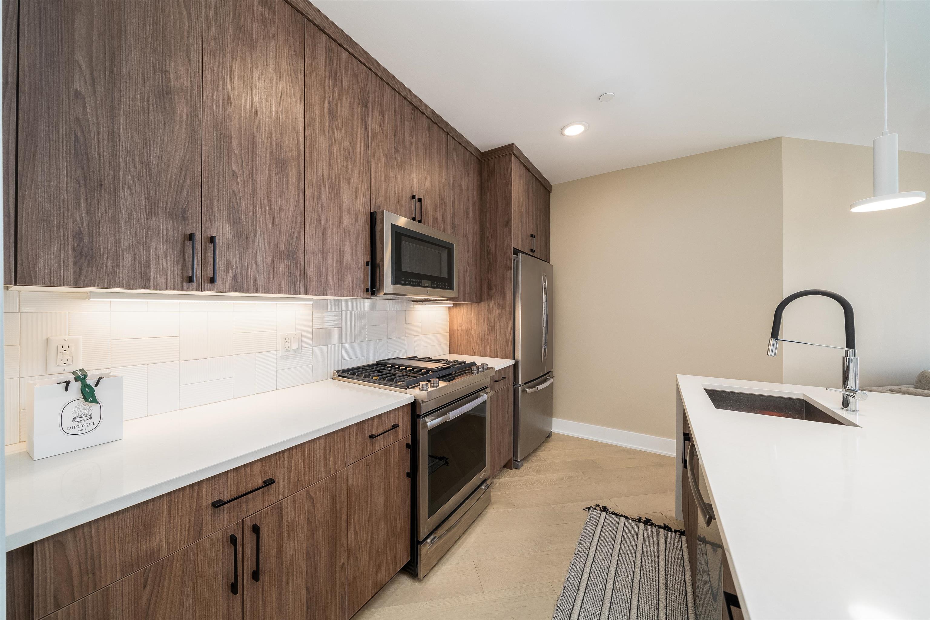 a kitchen with a sink a stove and cabinets