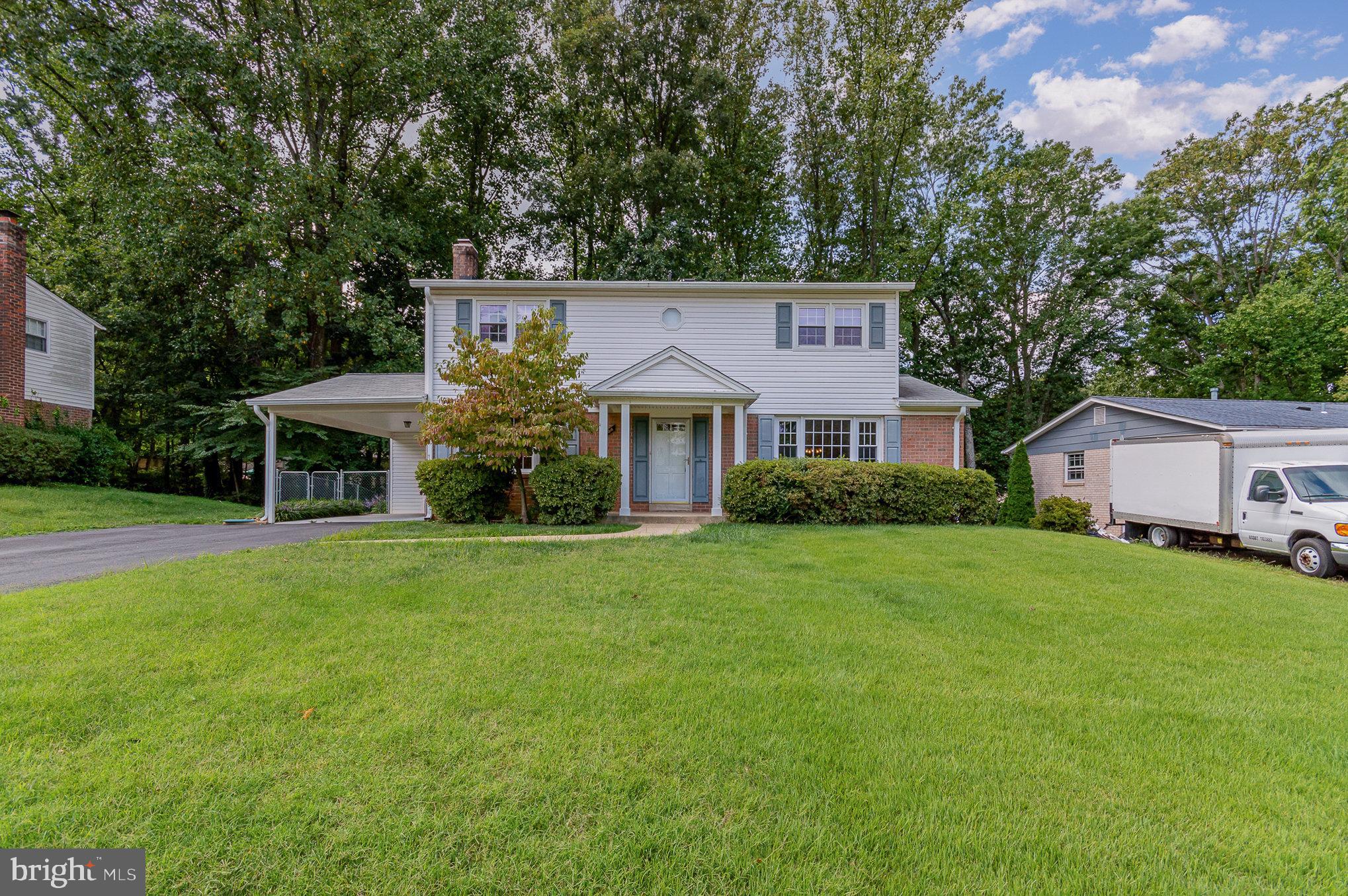 a front view of house with yard and trees in the background