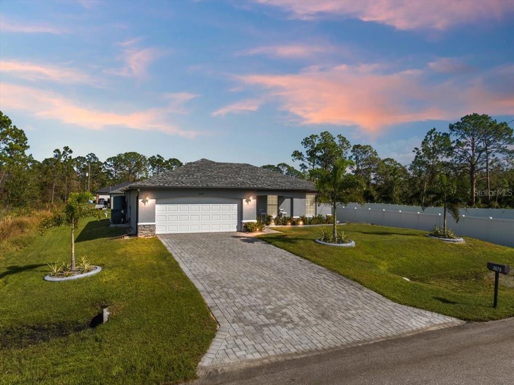 a view of a house with a yard and a garage