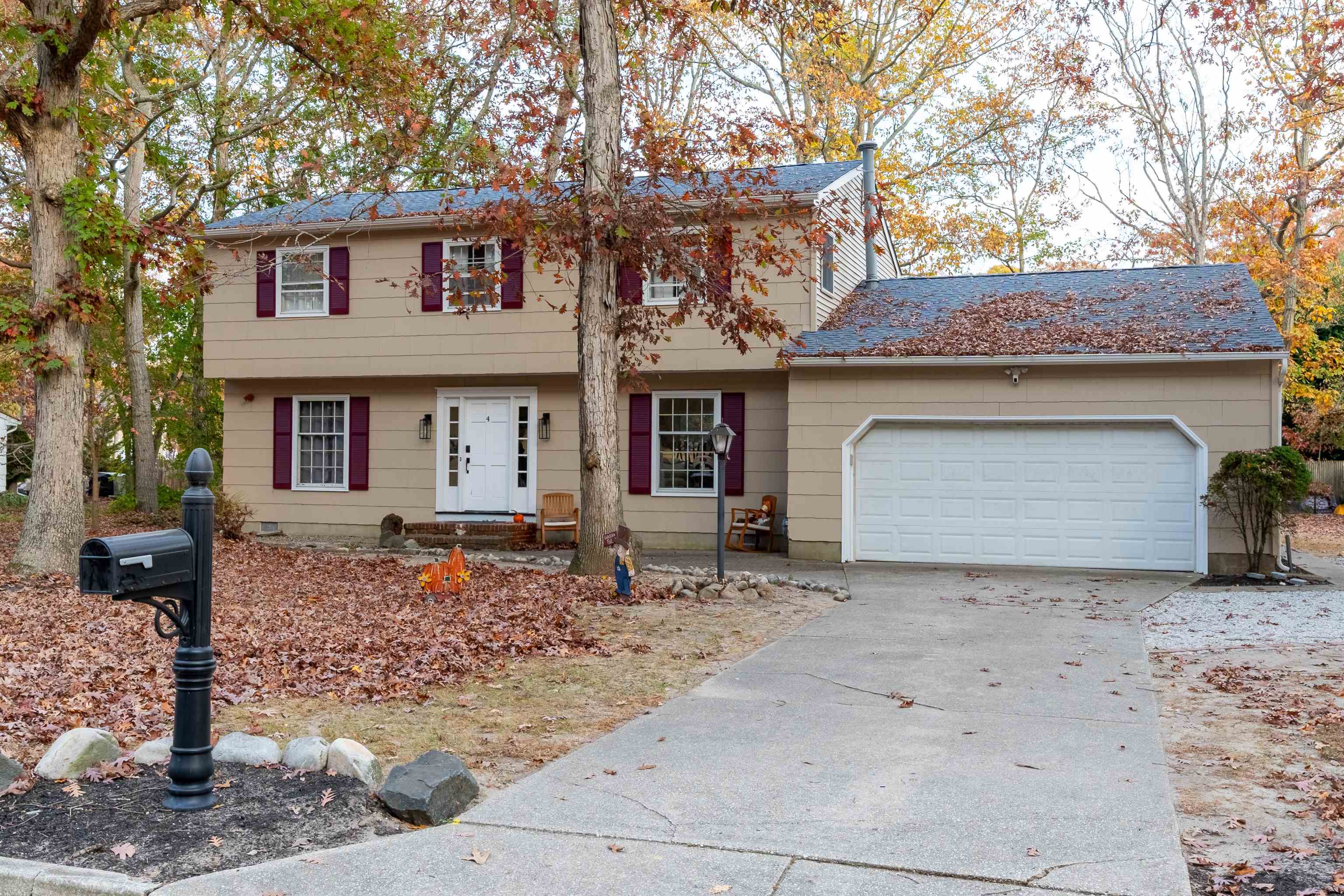 a front view of a house with a tree