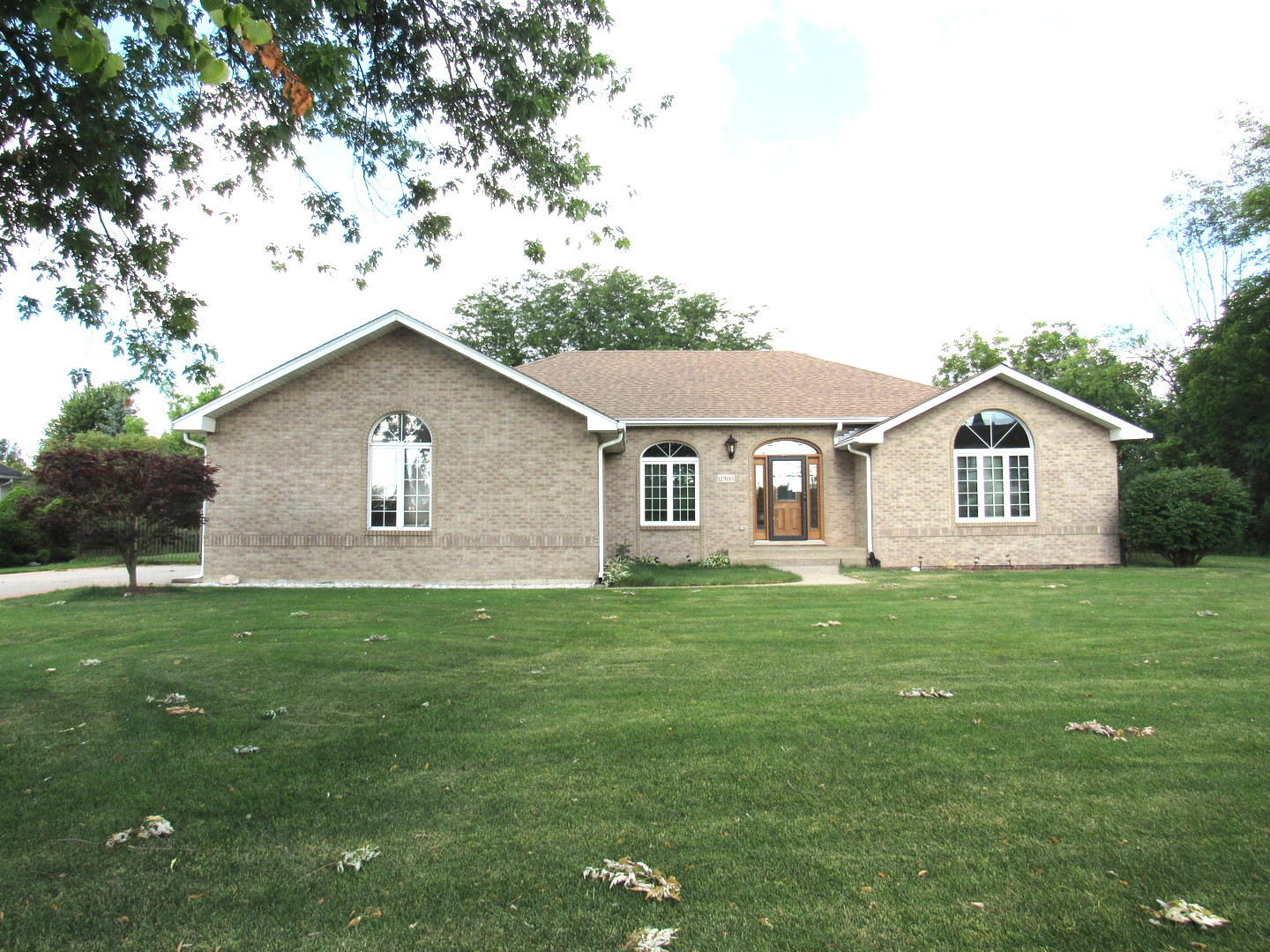 a view of a yard in front of a house with large trees